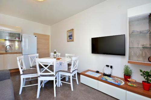 a living room with a dining room table and a tv at m & m in Podstrana