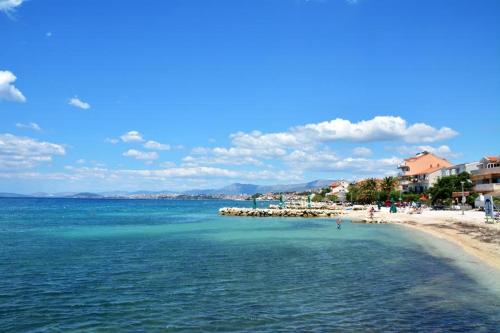 a beach with a group of people in the water at m & m in Podstrana