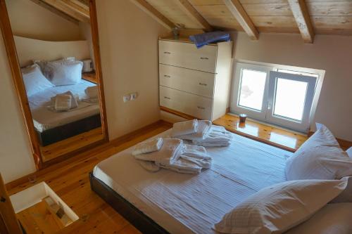 sypialnia z 2 łóżkami i dużym lustrem w obiekcie Dolichi Studio w mieście Samos