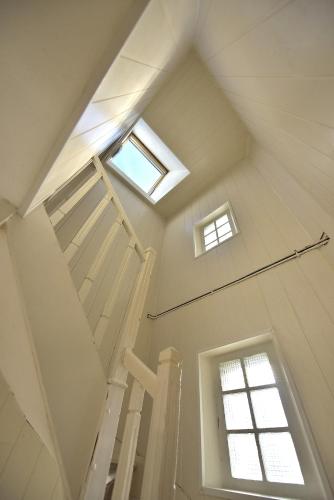 - un escalier blanc avec deux fenêtres dans le grenier dans l'établissement Studio 