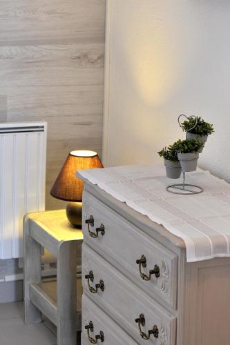 une commode avec une plante au-dessus d'une lampe dans l'établissement Studio 