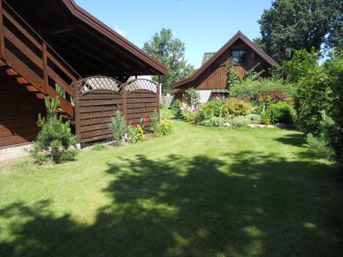 a yard with a house and a garden with a lawn sidx sidx sidx at Dom pod Lipą in Jaminy
