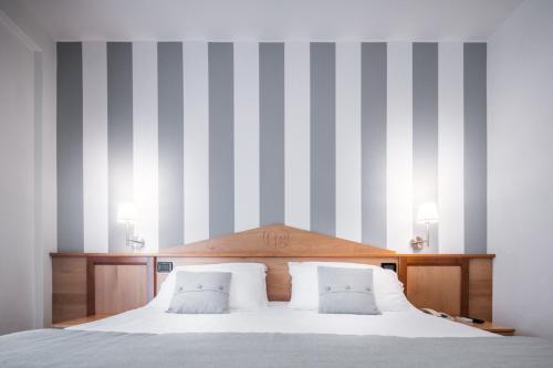 a bedroom with a large bed with striped walls at Hotel Bellavista in Lignano Sabbiadoro