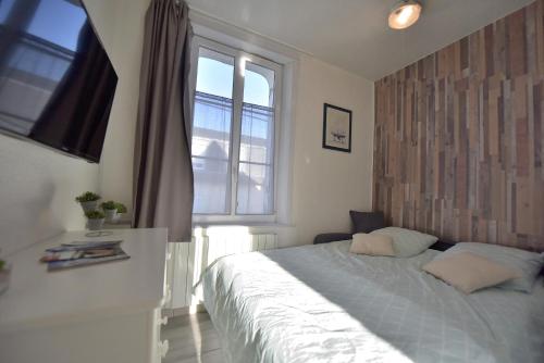 a bedroom with a large bed and a window at Studio "La Plage" - 50m Front de Mer in Berck-sur-Mer