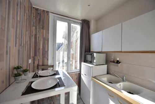 a kitchen with two sinks and a microwave at Studio "La Plage" - 50m Front de Mer in Berck-sur-Mer