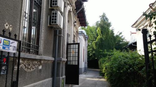 an alley with a black door on a building at Friends Hostel in Bucharest