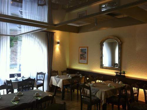 a dining room with tables and chairs and a mirror at Tauberhotel Kette in Wertheim