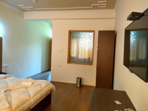 a bedroom with a bed and a table and a window at Shaolin Ladakh in Leh