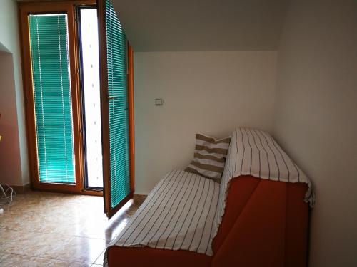 un letto in un angolo di una camera con due finestre di Apartment Babovic Orahovac Kotor a Kotor (Cattaro)