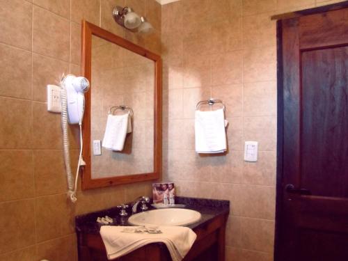 W łazience znajduje się umywalka i lustro. w obiekcie Costa Serrana Apart Hotel w mieście Mina Clavero