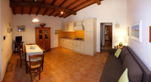 a kitchen and a living room with a couch and a table at Agriturismo Le Pescine in Vada