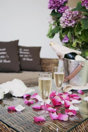 two glasses of champagne and pink flowers on a table at Hotel Ca' Bianca in Riccione