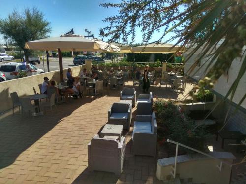 a group of people sitting at tables in a restaurant at Hotel Lady Mary in Milano Marittima