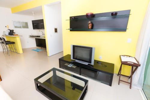 a living room with a flat screen tv on a table at Cumbuco Kite Village Deluxe in Cumbuco