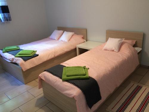 two beds with green towels on them in a room at Apartamenty Rodzinne Puck Katarzyna Pietruszkiewicz in Puck