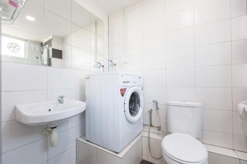 a white bathroom with a toilet and a washing machine at 3-Bed Executive Suite, RumahKu @CEO in Bayan Lepas