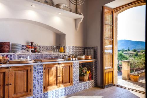 a kitchen with a counter and an open door at Fincahotel Can Estades in Calvià