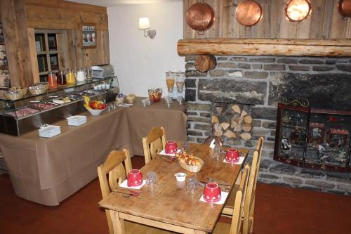 een eetkamer met een tafel met rode gerechten erop bij Hôtel Restaurant U'Fredy in La Clusaz
