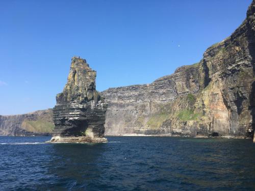 a large rock formation in the middle of the water at The Burren Hostel - Sleepzone in Lisdoonvarna