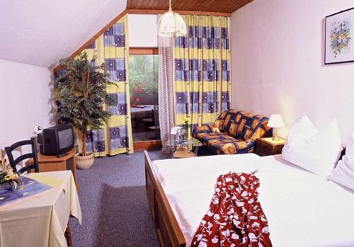 ein Schlafzimmer mit einem Bett und einem Sofa in einem Zimmer in der Unterkunft Gasthof Steinbräu in Faistenau