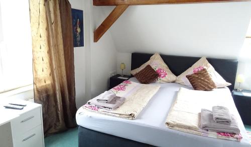 a bedroom with a white bed with towels on it at Alb Hotel Schalksburg in Albstadt