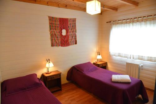 Un dormitorio con dos camas y una ventana. en Nothofagus Bed & Breakfast, en El Chaltén
