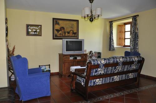 een woonkamer met een bank en een tv bij Posada la Torre in Serdió