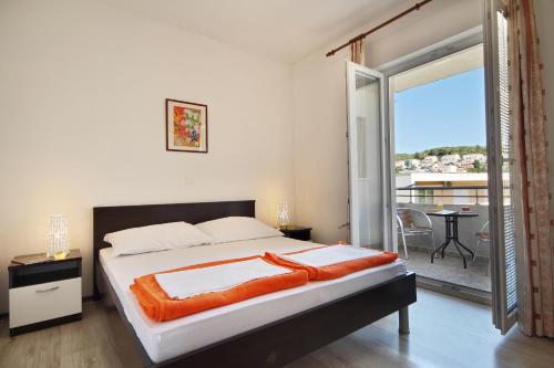 a bedroom with a large bed and a balcony at Vukosav Family Apartments and Rooms in Dubrovnik