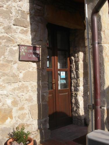 a door to a building with a sign on it at Locanda La Rosa in Pauli Arbarei