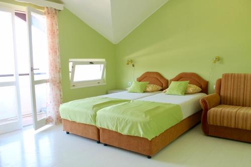 1 dormitorio con 1 cama con silla y ventana en Apartments Villa Milna 2, en Budva