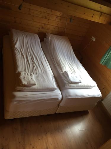 a bed in a room with white sheets at Ytri Vík in Hauganes