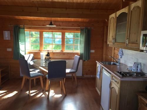 a kitchen with a table and chairs and a window at Ytri Vík in Hauganes