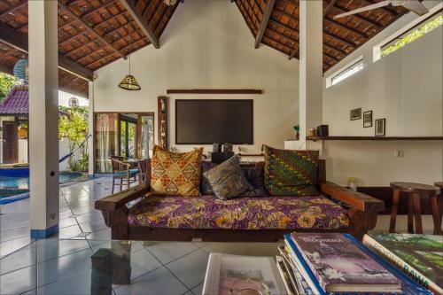 a living room with a couch and a flat screen tv at Ambary House Gili Trawangan- 2 BR Private Villa, Pool in Gili Trawangan
