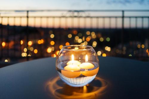 a glass vase with candles sitting on a table with a view at Antica Torre di Iuso in Matera