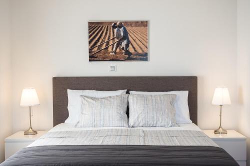 a bedroom with a large bed with two lamps at Apartments Nino 1 in Zadar
