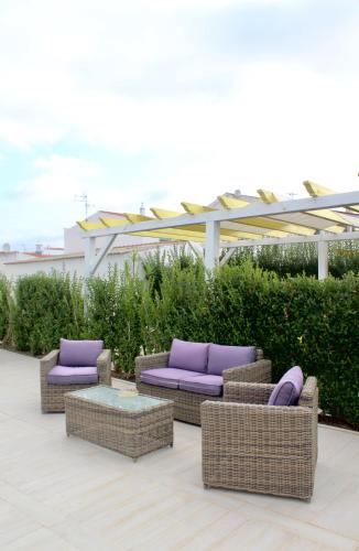 a group of couches and chairs on a patio at Quinta Da Rosa Linda in Monte Gordo