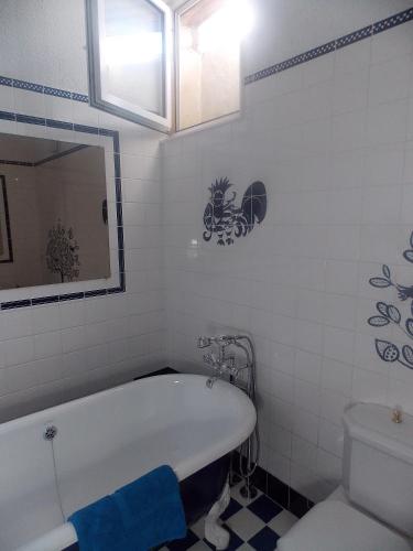 a bathroom with a bath tub and a toilet at Les Gîtes De Morville in Malaumont