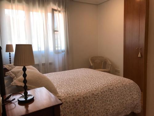 カンガス・デ・オニスにあるApartamento Horreo Centro Cangas de Onisのベッドルーム1室(ベッド1台、テーブルの上にランプ付)