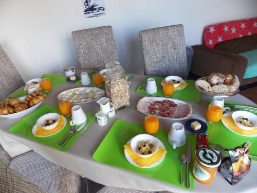 un tavolo con prodotti per la colazione in cima di Le Petit Breuil a Verteillac