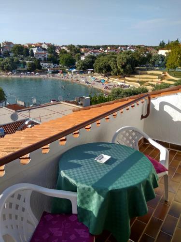 a table on a balcony with a view of a body of water at Suran Apartments in Pula