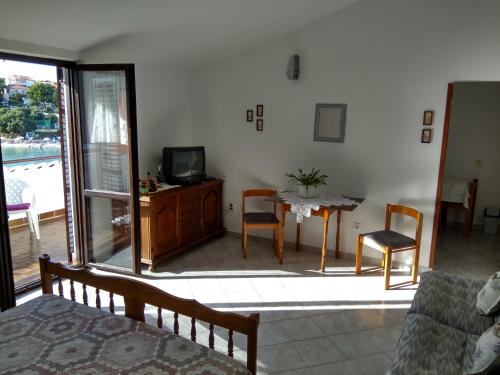 a living room with a television and a table with chairs at Suran Apartments in Pula