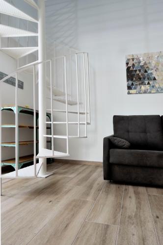 a living room with a black couch and a staircase at Plaza Sandra in Trujillo