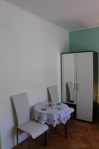 a dining room with a table and chairs and a mirror at Apartments Milatic in Jelsa