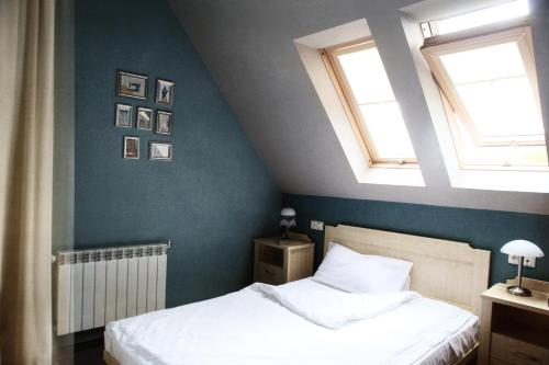 a bedroom with two windows and a bed with white sheets at Villa Elise Park Pension in Stronie Śląskie