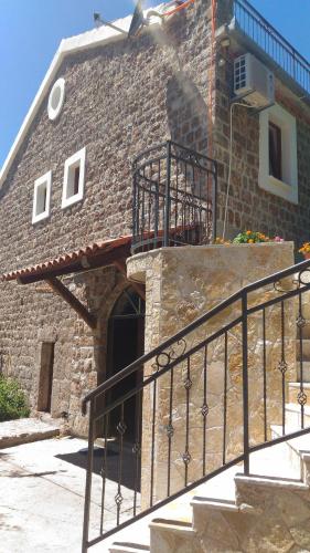 a brick building with a staircase leading to a door at Apartment Mond in Virpazar