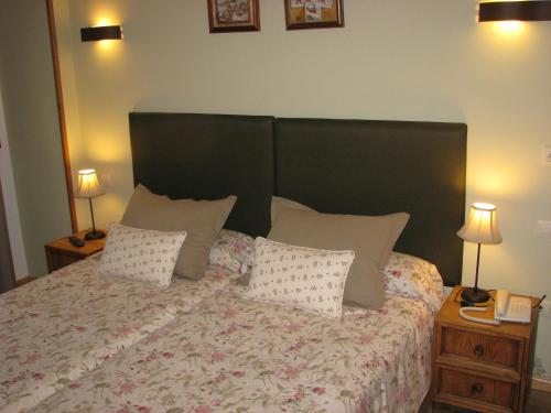 a bedroom with a large bed with pillows on it at Aparthotel Sarrato in Sallent de Gállego