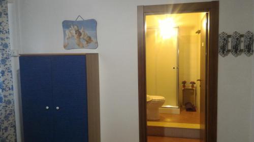a bathroom with a blue door and a toilet at Antico Frantoio Rooms in Sambuca di Sicilia