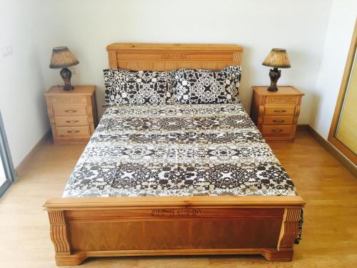 Schlafzimmer mit einem Bett mit einer schwarzen und weißen Bettdecke in der Unterkunft Paradise beach in Mohammedia