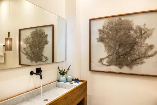 a bathroom with a sink and two pictures on the wall at Nyx Chic Manor in Chania Town