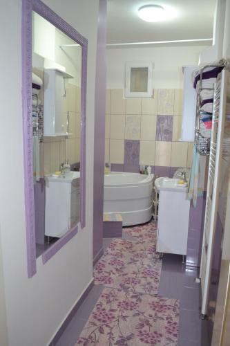 a bathroom with two sinks and a tub and a mirror at Casa Maria in Şura Mică